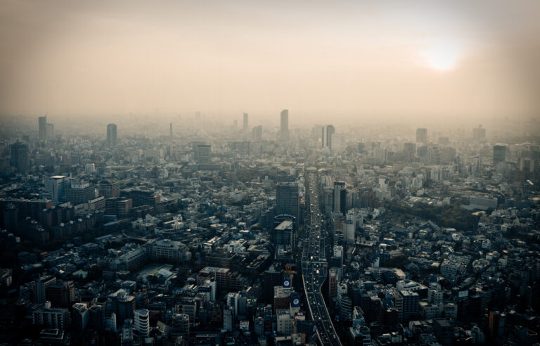 Hazy city skyline at sunset under thick smog, a reminder that air pollution can trigger asthma symptoms