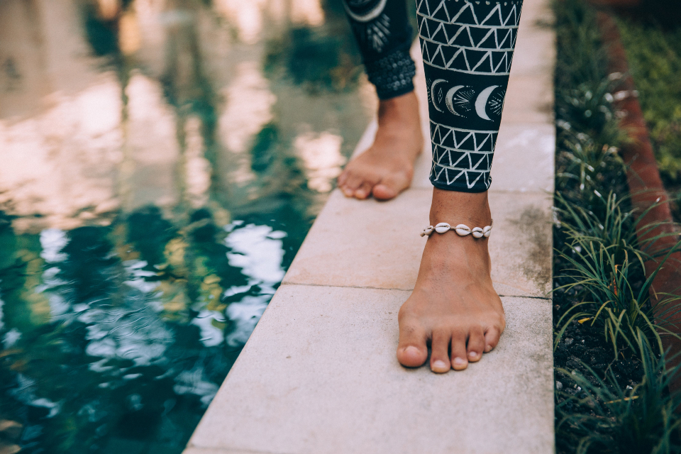 Close-up of bare feet stepping along a stone path, a reminder to check your feet every day for changes