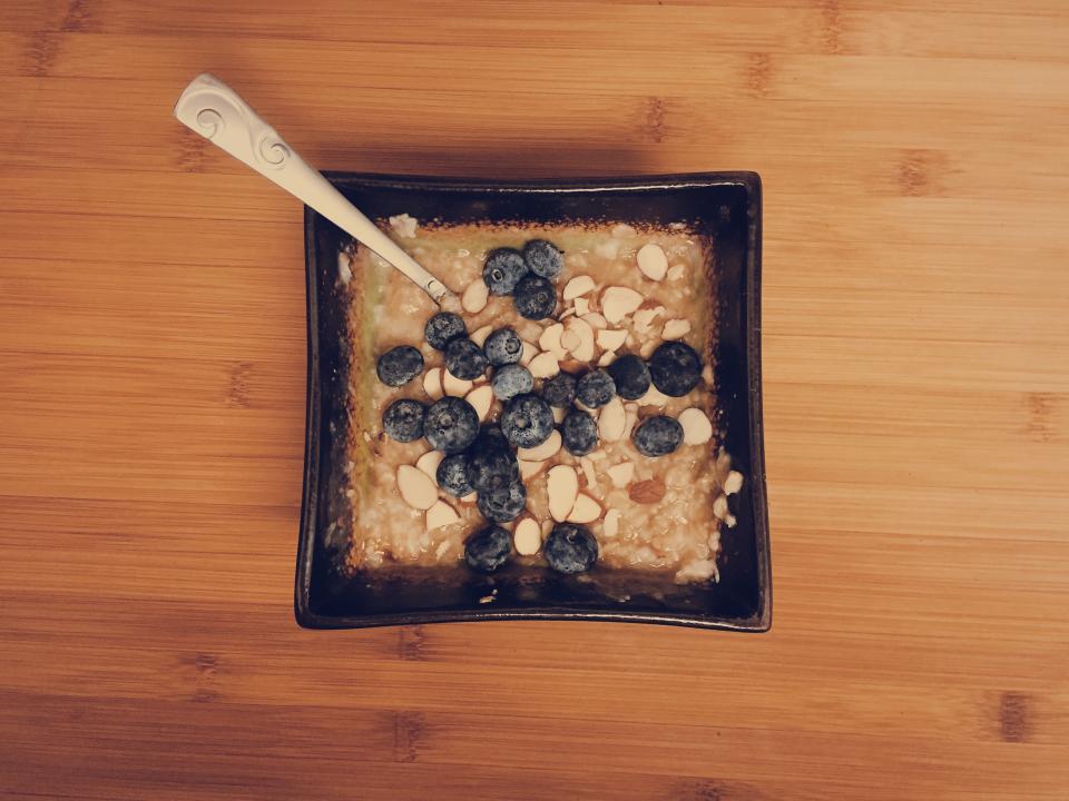 Bowl of oatmeal topped with blueberries on a wooden table, a high-fiber breakfast for healthy digestion