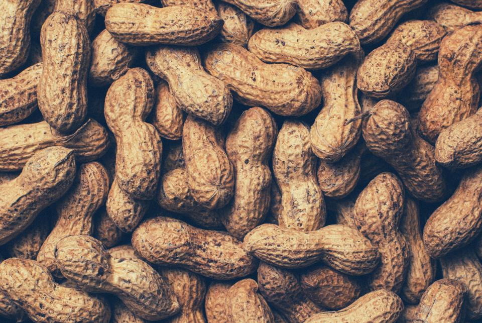 Close-up of a pile of peanuts in their shells, one of the most common food allergens