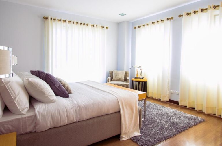 Tidy bedroom with a made bed, soft pillows and light curtains, a comfortable space for restful sleep