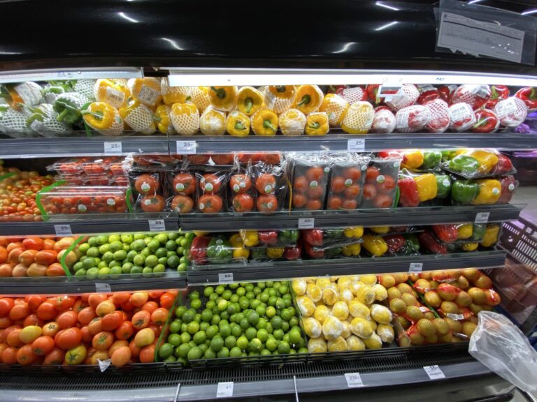 Supermarket shelves of packaged peppers and tomatoes with price tags and labels, ready to compare