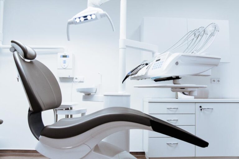 Modern dental treatment room with a dental chair and overhead light, where a dentist can check the cause of sensitive teeth