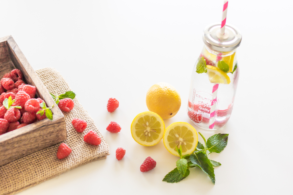 Bottle of fruit-infused water with lemon, mint and raspberries, a simple way to drink more water each day